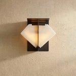 Freya Angular Alabaster Wall Sconce | Studio Front Presentation | Front view of the illuminated angular folded envelope-shaped stone sconce radiating a warm golden glow | Severn Lighting