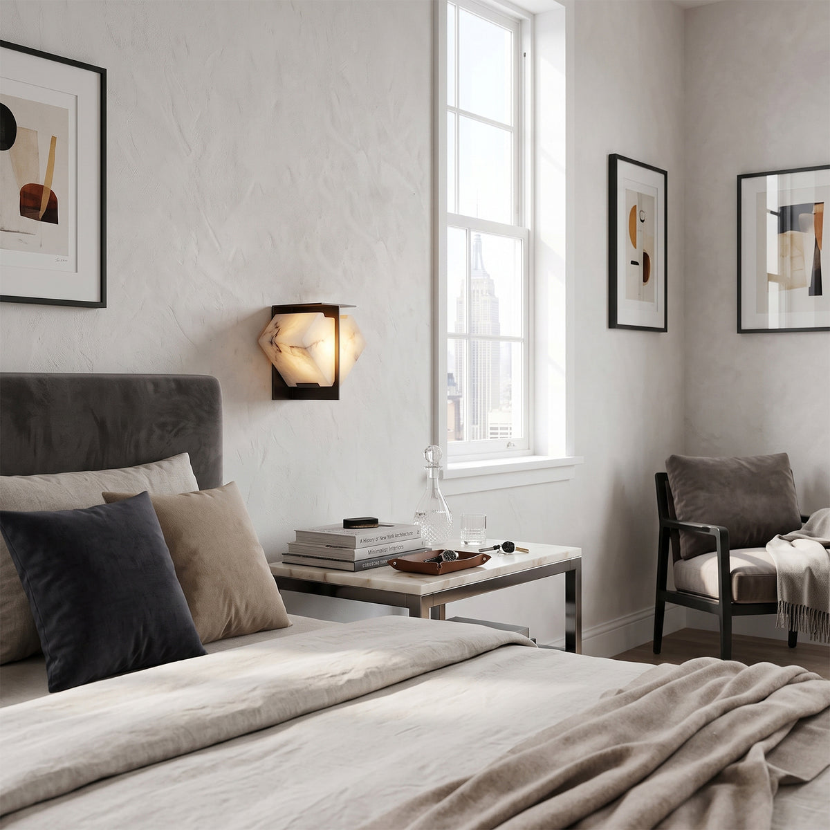 Freya Angular Alabaster Wall Sconce | Minimalist Bedroom | Positioned as a sleek bedroom wall light fixture casting a cozy golden halo near a bed with dark grey cushions | Severn Lighting
