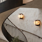 Freya Angular Alabaster Wall Sconce | Staircase Wall Sconces | Two illuminated architectural wall lamps mounted along a dramatic curved concrete spiral staircase wall | Severn Lighting