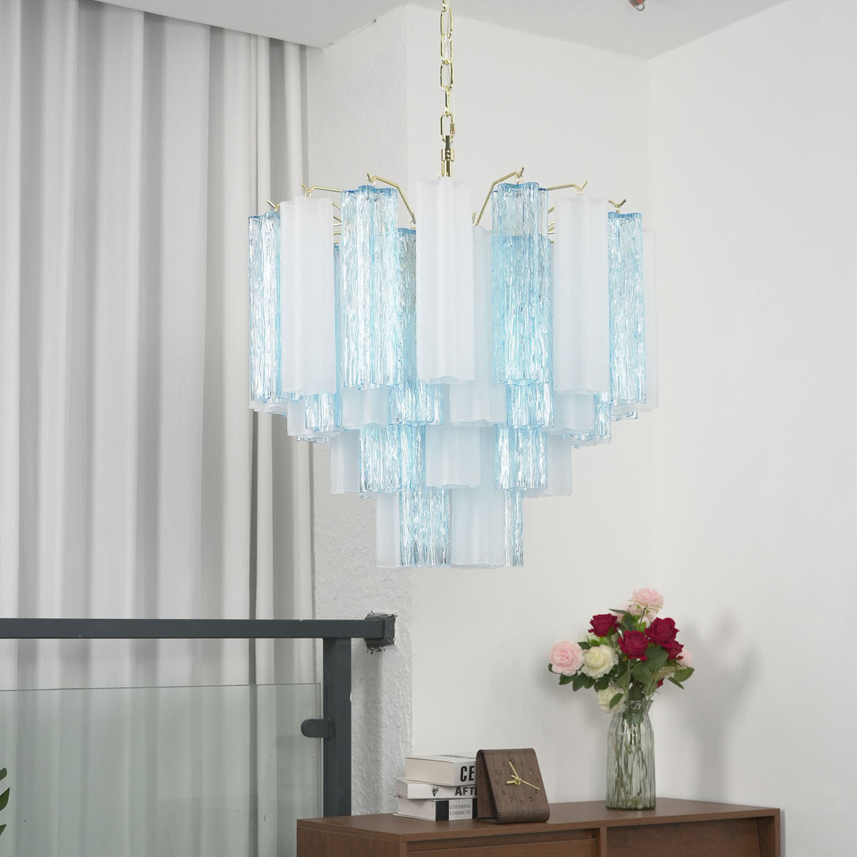 Givrane Two-Tone Glass Tube Tiered Chandelier | Two-Tone Glass and Brass | Real-life installation view hanging near a glass balcony hallway | Severn Lighting