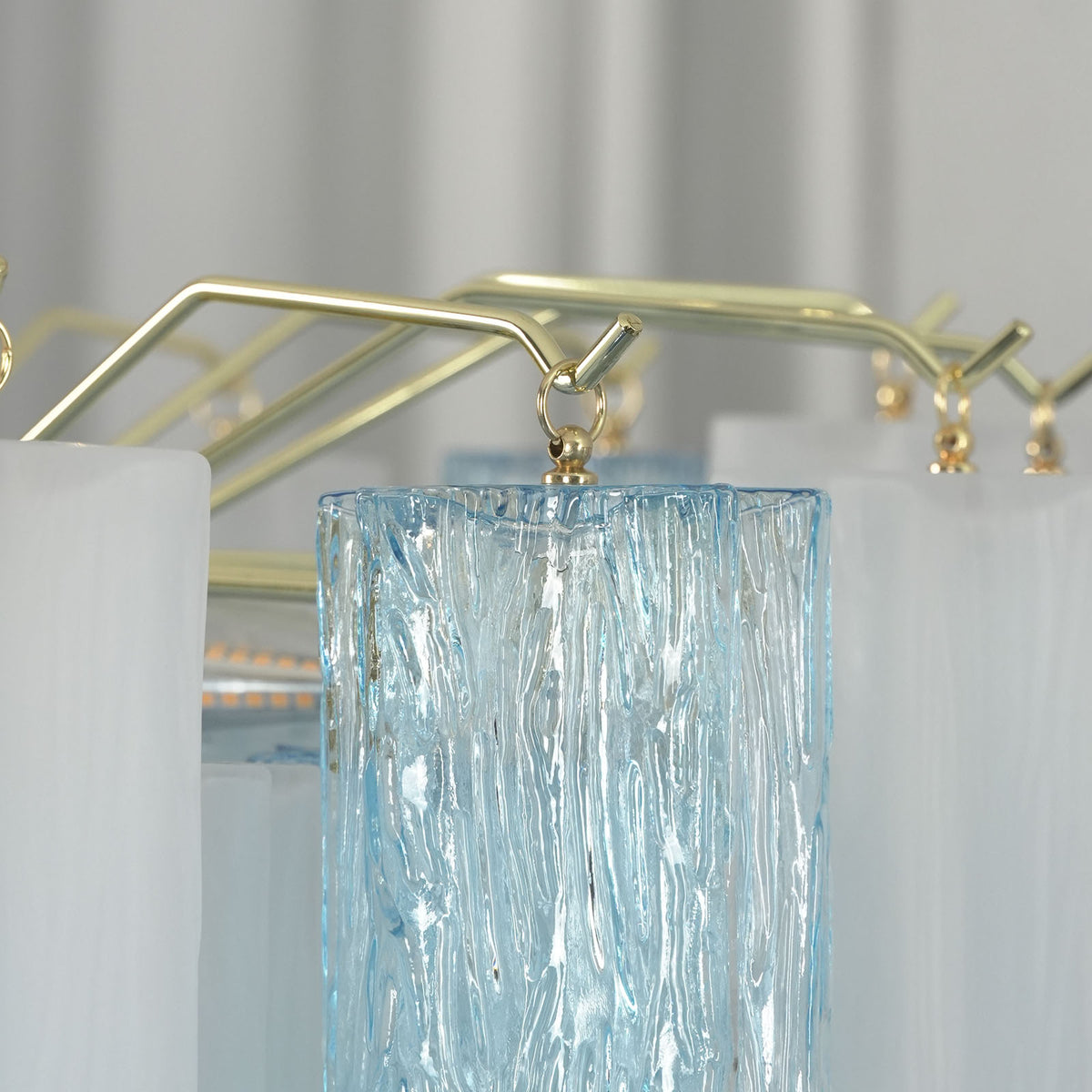 Givrane Two-Tone Glass Tube Tiered Chandelier | Two-Tone Glass and Brass | Close-up view of the top brass frame and glass tube hanging hardware | Severn Lighting