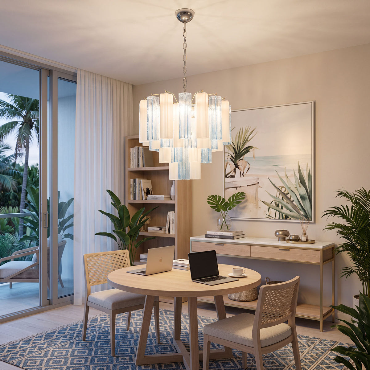 Givrane Two-Tone Glass Tube Tiered Chandelier | Two-Tone Glass and Brass | Displayed over a round study table in a casual room with balcony doors | Severn Lighting