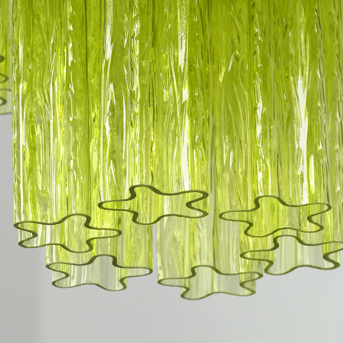Green Glacier Tier Chandelier | Textured Green Glass | Extreme close-up shot of the ruffled wavy bottom edges of the translucent green glass panels | Severn Lighting