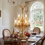 Isambard Candelabra Table Lamp | Cut Crystal and Brass | Centered on a large wooden dining table in a formal dining room | Severn Lighting