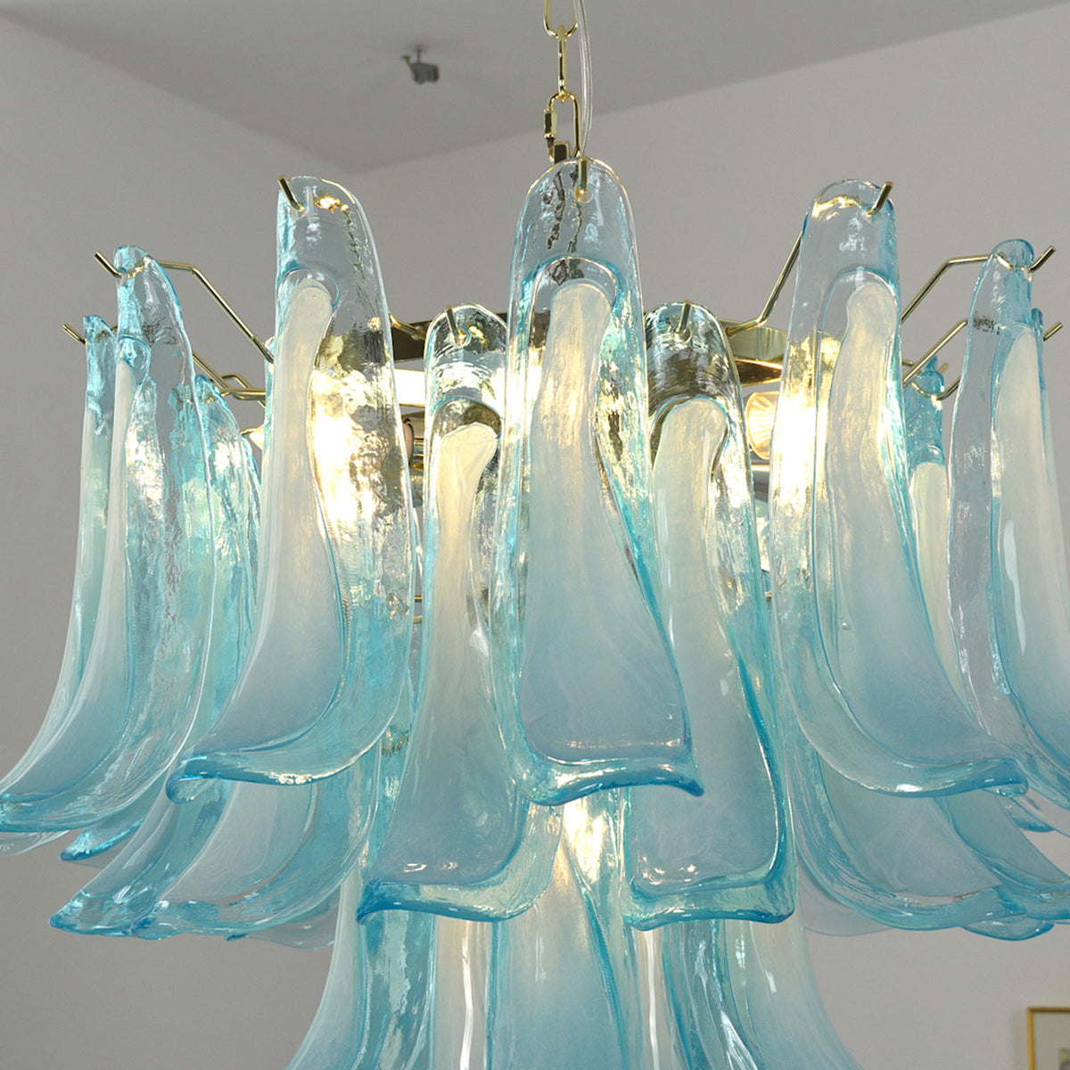 Isar Blue Petal Glass Chandelier | Blue Glass and Brass | Medium close-up showing the central brass frame and glowing blue petals | Severn Lighting