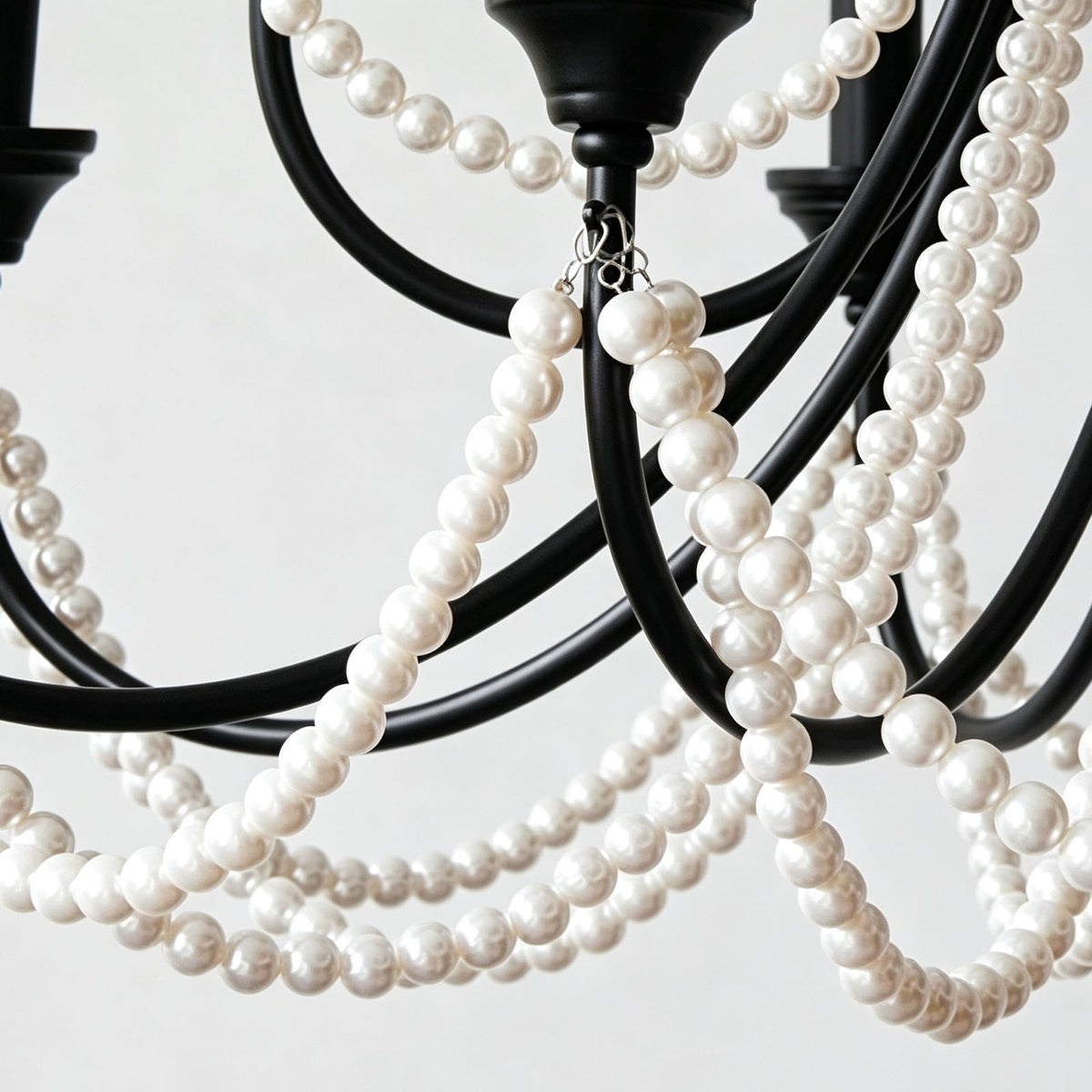 Isolde Pearl Swag Candle Chandelier | Pearl Beads, Crystal and Metal | Close-up view of the black metal frame and draped white pearl swags | Severn Lighting