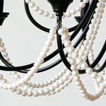 Isolde Pearl Swag Candle Chandelier | Pearl Beads, Crystal and Metal | Close-up view of the black metal frame and draped white pearl swags | Severn Lighting