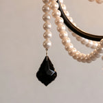 Isolde Pearl Swag Candle Chandelier | Pearl Beads, Crystal and Metal | Macro shot of a black faceted teardrop crystal pendant and pearl strand | Severn Lighting