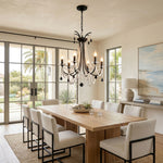 Isolde Pearl Swag Candle Chandelier | Pearl Beads, Crystal and Metal | Suspended over a dining table with light-colored modern chairs | Severn Lighting