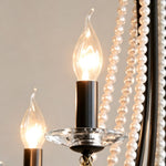 Isolde Pearl Swag Candle Chandelier | Pearl Beads, Crystal and Metal | Detail shot highlighting an illuminated candle bulb and glass bobeche dish | Severn Lighting