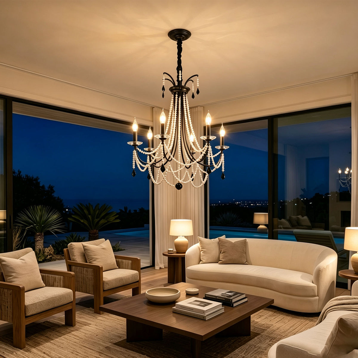 Isolde Pearl Swag Candle Chandelier | Pearl Beads, Crystal and Metal | Hanging in a night-view living room with white sofas and ocean scenery | Severn Lighting