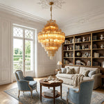 Kester Amber Glass Tier Chandelier | Amber Glass and Brass | Centered in an elegant living room featuring bookshelves and armchairs | Severn Lighting