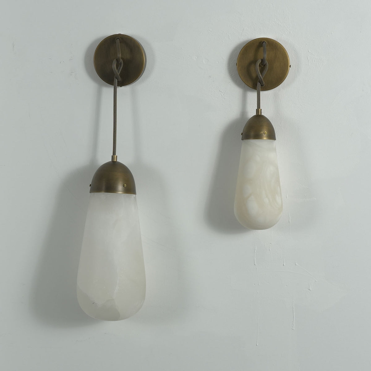 Larmelle Teardrop Sconce | Alabaster and Brass | Duo of two sizes hanging unlit on white wall | Severn Lighting