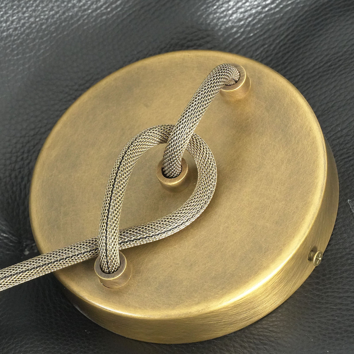 Larmelle Teardrop Sconce | Antique Brass | Detailed view of circular brass backplate and looped cord | Severn Lighting