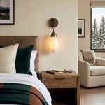 Larmelle Teardrop Sconce | Alabaster and Brass | Bedside accent lighting above wooden nightstand | Severn Lighting