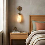 Larmelle Teardrop Sconce | Alabaster and Brass | Mounted beside wooden headboard in neutral bedroom | Severn Lighting