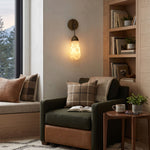 Larmelle Teardrop Sconce | Alabaster and Brass | Mounted in a cozy reading corner beside an armchair | Severn Lighting