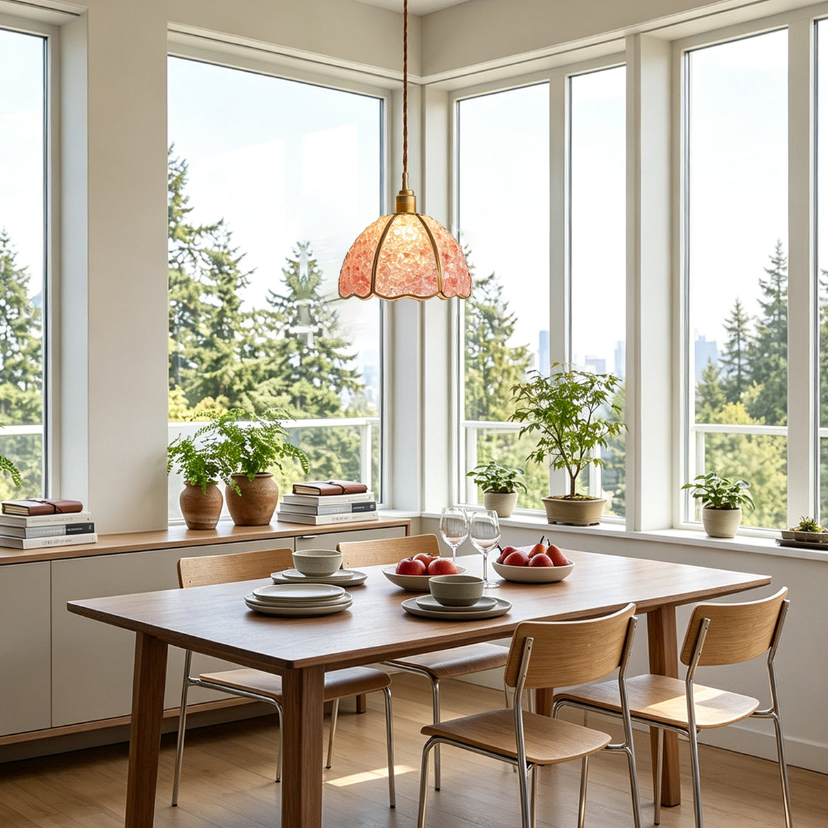 Liora Mosaic Glass Pendant Light | Pink Mosaic Glass and Brass | Positioned over a dining table setup near corner windows showcasing green forest scenery | Severn Lighting