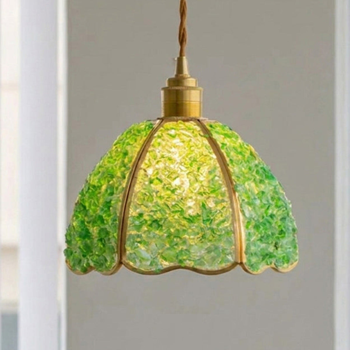 Liora Mosaic Glass Pendant Light | Green Mosaic Glass and Brass | Studio view of the green mosaic glass fixture fully lit and glowing against a neutral wall | Severn Lighting
