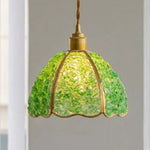 Liora Mosaic Glass Pendant Light | Green Mosaic Glass and Brass | Studio view of the green mosaic glass fixture fully lit and glowing against a neutral wall | Severn Lighting