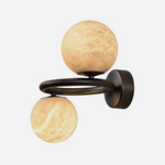 Lucern Twin Globe Alabaster Wall Sconce | Natural Alabaster and Matte Black Metal | Front studio shot on a clean white background showing the twin glowing stone spheres and curved ring arm | Severn Lighting