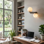 Lucern Twin Globe Alabaster Wall Sconce | Natural Alabaster and Matte Black Metal | Mounted on a wall next to a tall bookshelf and a wooden study desk with a laptop | Severn Lighting