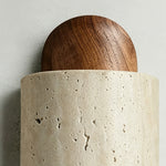 Lyra Travertine Shield Wall Lamp | Travertine, Wood, Metal | Macro close-up showcasing the contrast between the smooth polished walnut wood dome and porous beige travertine stone | Detail shot | Severn Lighting