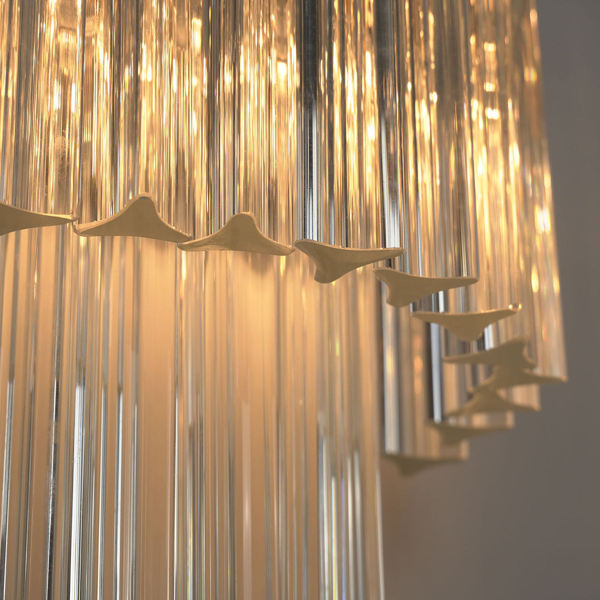 Marelle Glass Rod Tiered Wall Lamp | Clear Glass Rods and Metal | Close-up view highlighting the glowing layered clear glass rods | Severn Lighting