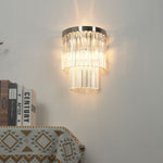 Marelle Glass Rod Tiered Wall Lamp | Clear Glass Rods and Metal | Real-life installation view glowing brightly on a wall above books | Severn Lighting