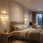 Marelle Glass Rod Tiered Wall Lamp | Clear Glass Rods and Metal | Pair of sconces mounted on wall flanking a bed in a warm bedroom setting | Severn Lighting