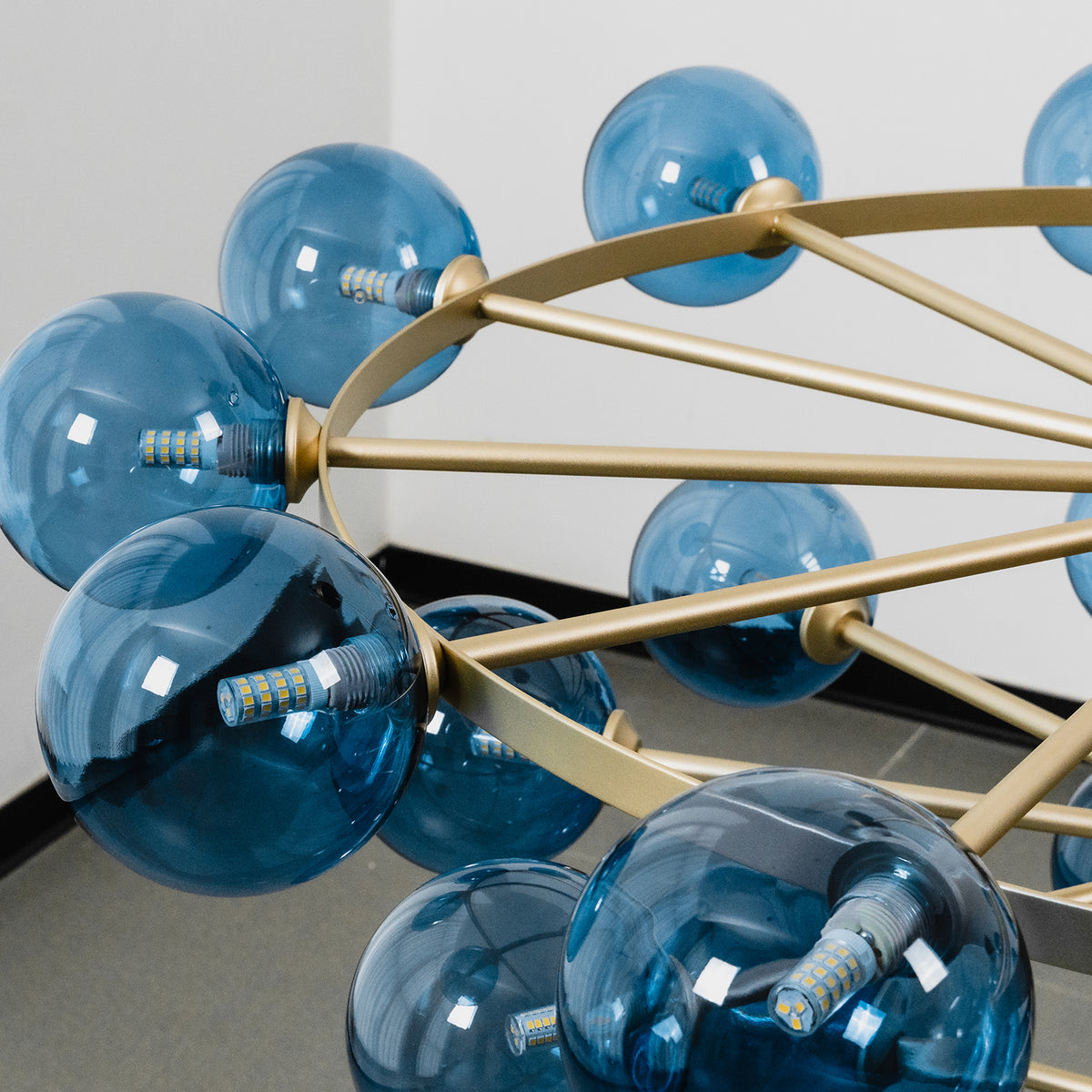 Marisol Aquamarine Glass Bubble Chandelier | Aquamarine Glass and Brass | Close-up top view showing brass radial arms holding blue glass globes | Severn Lighting
