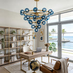 Marisol Aquamarine Glass Bubble Chandelier | Aquamarine Glass and Brass | Enhancing a modern home office with a wooden desk and open shelving | Severn Lighting
