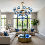 Marisol Aquamarine Glass Bubble Chandelier | Aquamarine Glass and Brass | Suspended over an L-shaped sectional sofa in a spacious lounge area | Severn Lighting