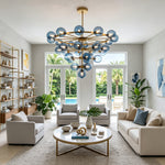 Marisol Aquamarine Glass Bubble Chandelier | Aquamarine Glass and Brass | Centered in a modern living room with white sofas and large glass doors | Severn Lighting