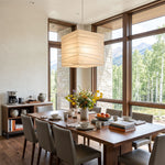 Marlen Squared Paper Column Pendant | Washi Paper and Metal | Hanging above a wooden dining table in a room with large windows | Severn Lighting
