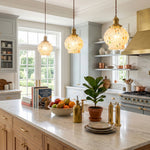 Marlowe Speckled Glass Pendant Lamp | Colorful Speckled Glass and Brass | Three pendants suspended over a long kitchen island counter with warm wooden cabinetry | Severn Lighting