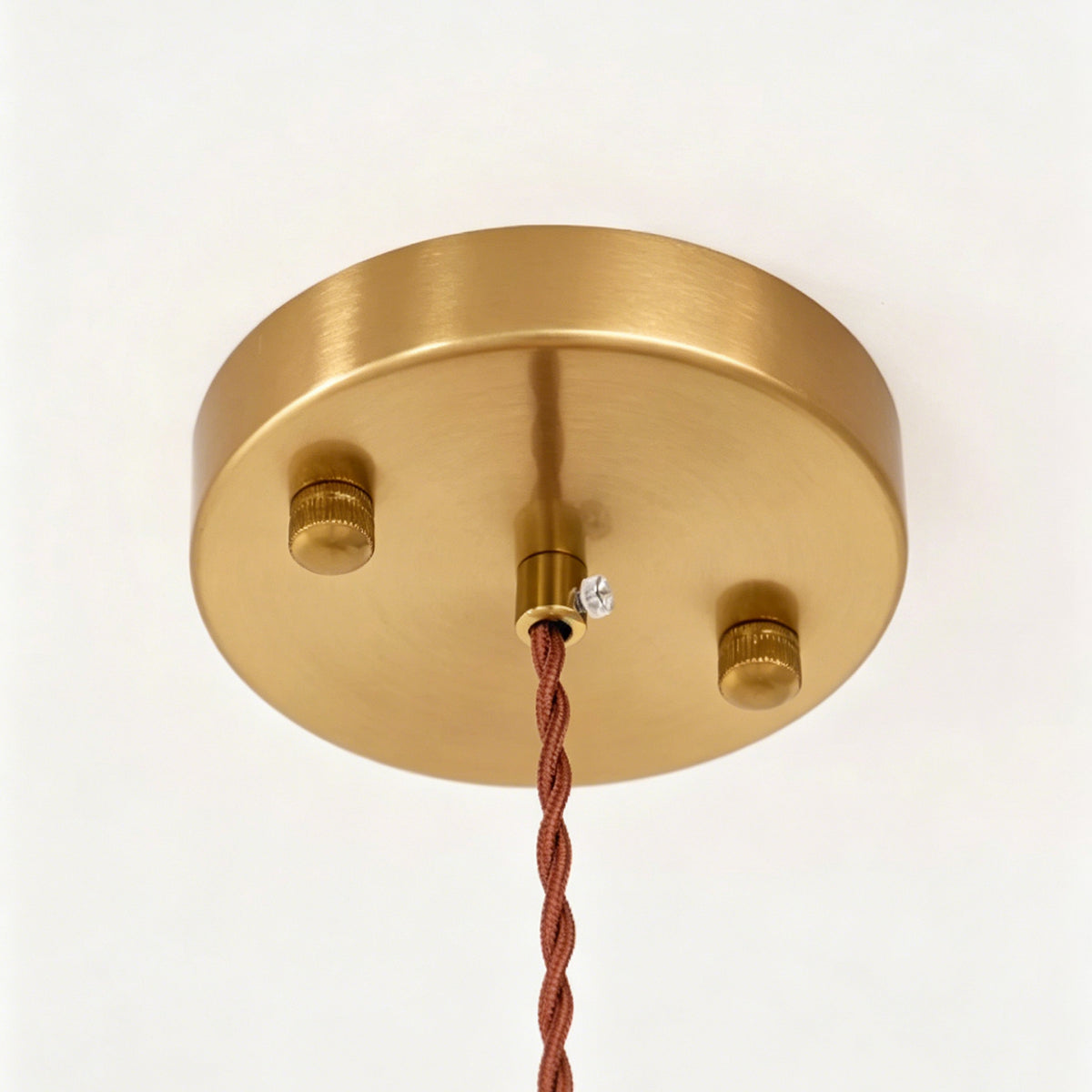 Marlowe Speckled Glass Pendant Lamp | Colorful Speckled Glass and Brass | Close-up macro detail showing the round brushed brass ceiling canopy and twisted fabric cord | Severn Lighting