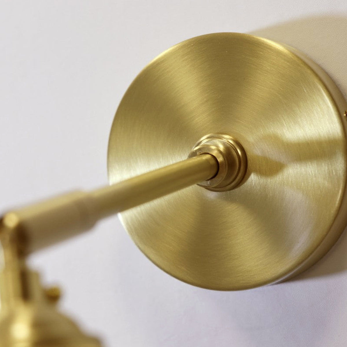 Merrick Fluted Glass Bell Wall Lamp | Fluted Glass and Brass | Close-up view of the circular brass mounting canopy and swing arm | Severn Lighting
