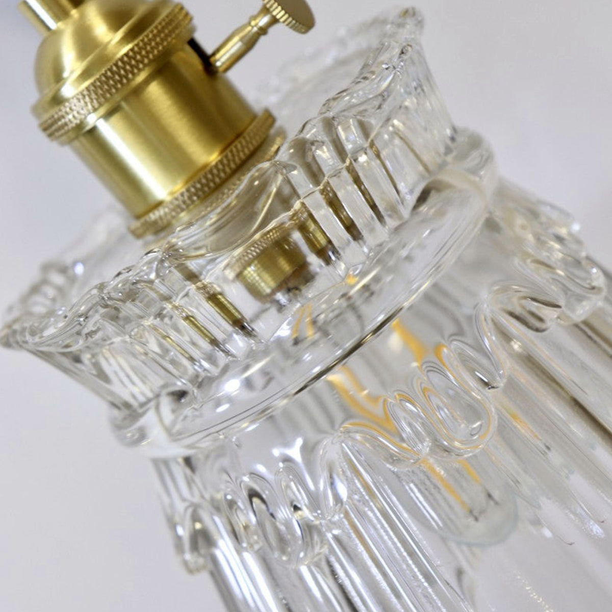 Merrick Fluted Glass Bell Wall Lamp | Fluted Glass and Brass | Close-up detail of the clear fluted glass bell-shaped shade | Severn Lighting
