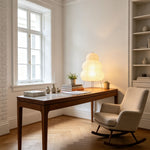 Nerine Tiered Washi Paper Table Lamp | Washi Paper and Metal | Illuminating a wooden desk near a window and a rocking chair | Severn Lighting