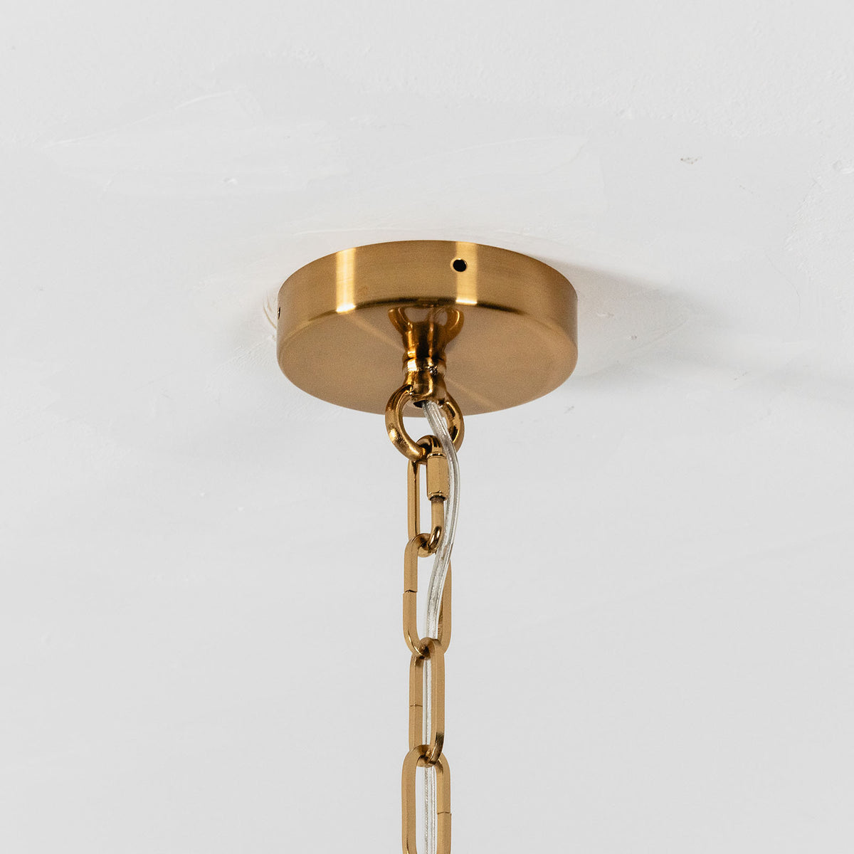 Nyle Tiered Glass Ring Chandelier | Textured Glass and Brass | Close-up view of the brass ceiling canopy and hanging chain hardware | Severn Lighting