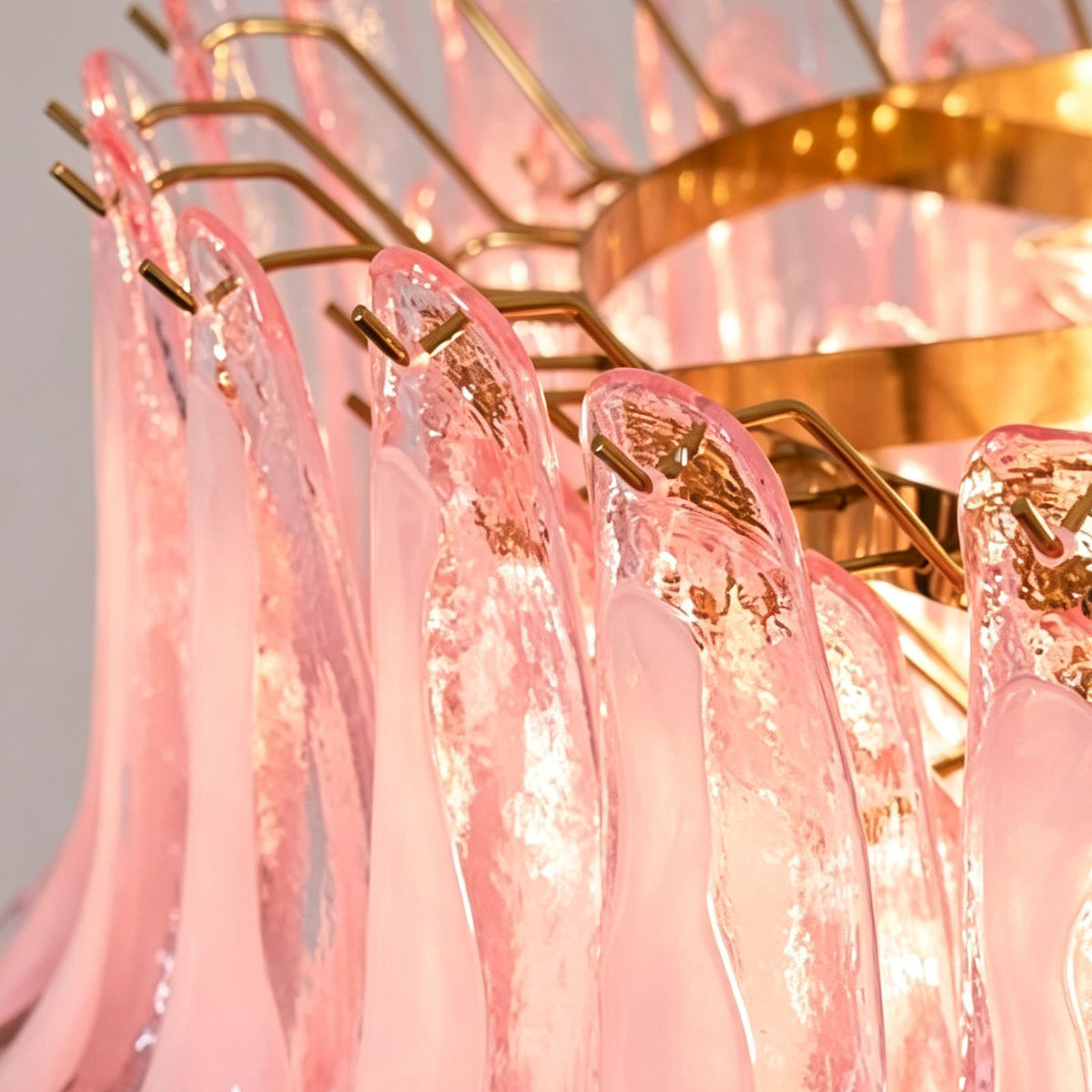 Ombeline Tiered Pink Glass Chandelier | Pink Glass and Brass | Close-up detail of the brass frame and hooks holding pink glass petals | Severn Lighting