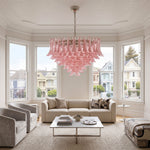 Ombeline Tiered Pink Glass Chandelier | Pink Glass and Brass | Centered above a coffee table in a bright living room with white sofa | Severn Lighting