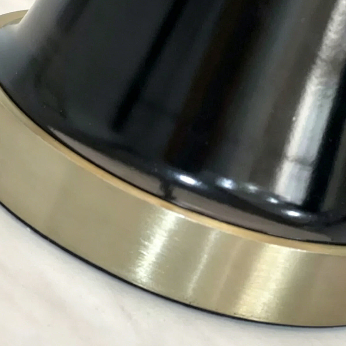 Orsino Alabaster Trapezoid Table Lamp | Natural Alabaster, Black Metal and Brass | Macro detail highlighting the glossy black base and brushed brass bottom ring | Severn Lighting