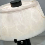 Orsino Alabaster Trapezoid Table Lamp | Natural Alabaster, Black Metal and Brass | Close-up of the illuminated trapezoid alabaster shade showing natural stone veins | Severn Lighting
