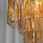 Orvelane Amber Swirl Glass Tiered Chandelier | Amber Swirl Glass and Brass | Close-up side view of cascading amber swirl glass panels on brass frame tiers | Severn Lighting