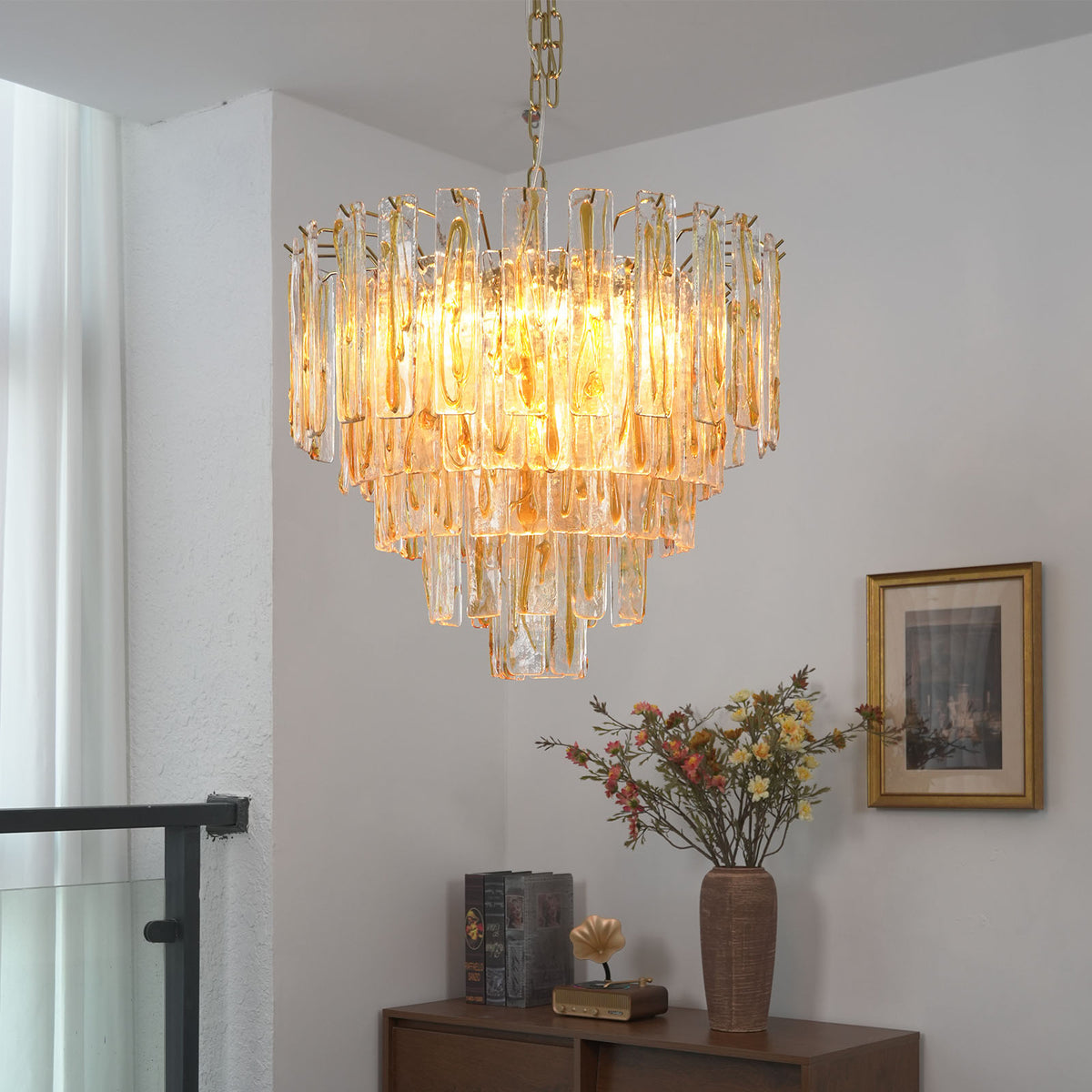 Orvelane Amber Swirl Glass Tiered Chandelier | Amber Swirl Glass and Brass | Real-life view hanging gracefully near a glass balustrade mezzanine balcony | Severn Lighting
