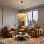 Orvelane Amber Swirl Glass Tiered Chandelier | Amber Swirl Glass and Brass | Displayed in a modern lounge area with tan leather armchairs and city skyline view | Severn Lighting