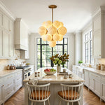 Ottoline Alabaster Cluster Chandelier | Natural Alabaster and Brass | Suspended over a sleek white kitchen island counter with matching wooden bar stools | Severn Lighting