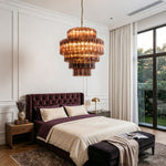 Ottoline Tiered Glass Chandelier | Textured Glass and Brass | Illuminating a modern bedroom above a dark tufted bed | Severn Lighting